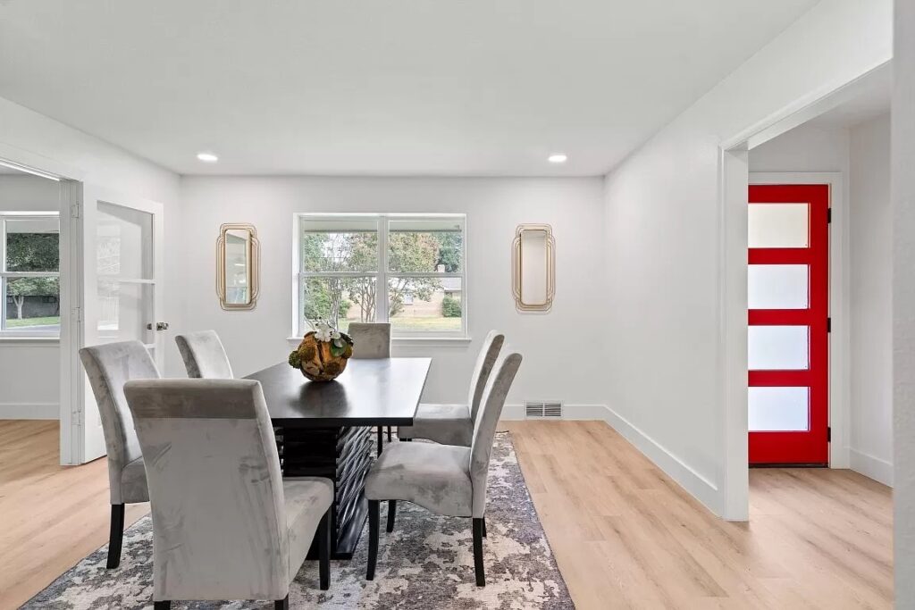 Home Stage in Dallas Fort Worth of dining area with large wooden table and 6 upholstered grey chairs