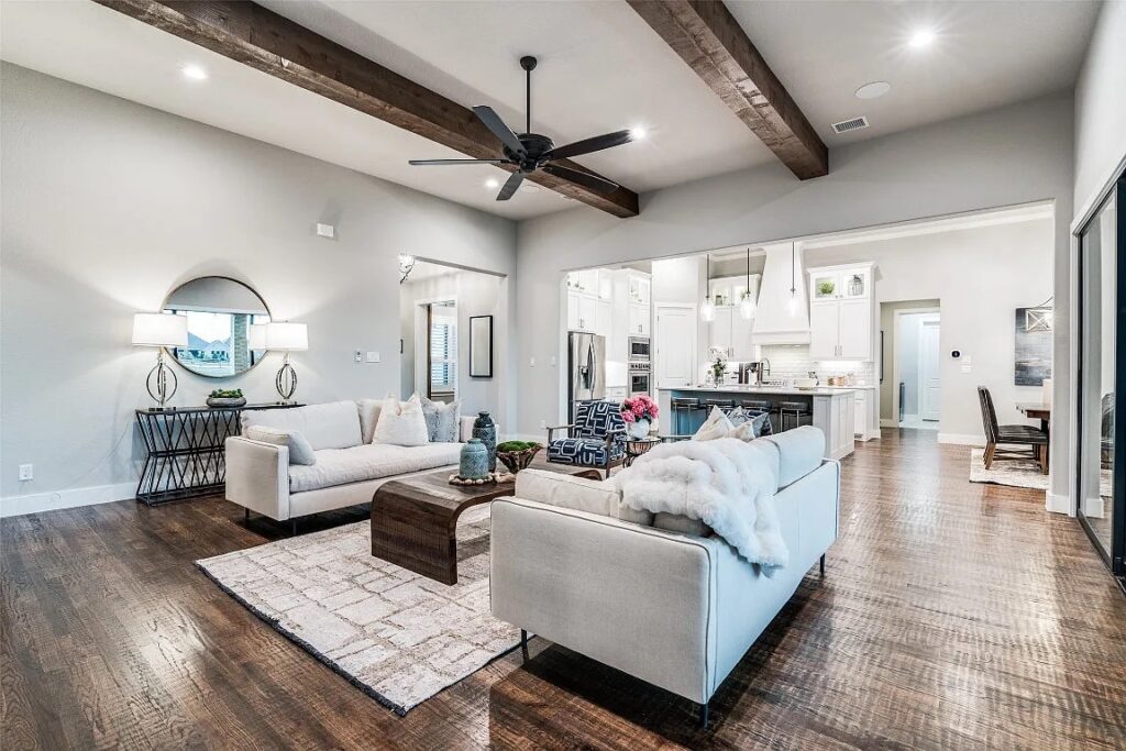 Living room home stage in Dallas with two large white sofas and two blue and white accent chairs.
