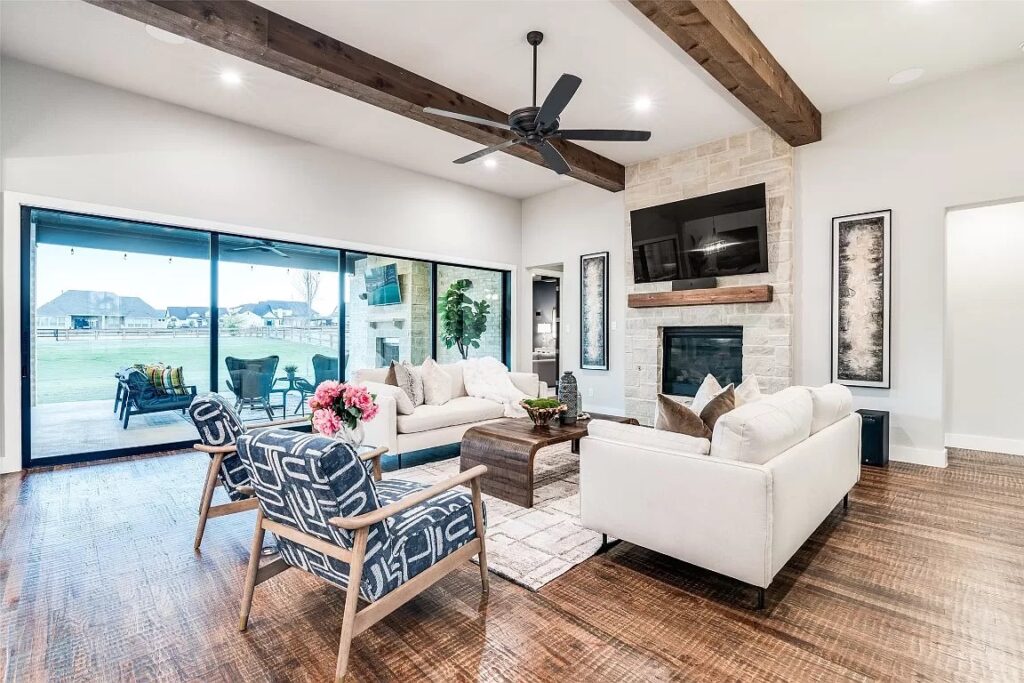 Living room home stage in Dallas with two large white sofas and two blue and white accent chairs.