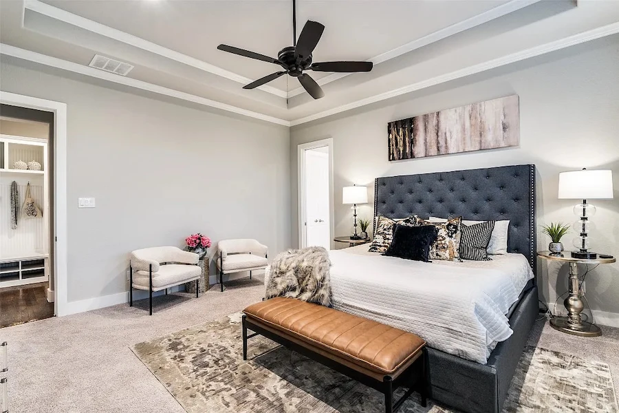Primary bedroom staged with cozy bedding and a seating area
