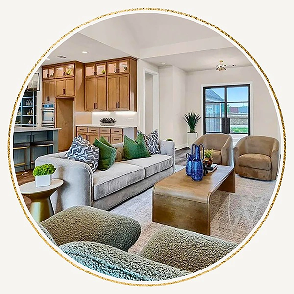 Staged living room with grey sofa, green pillows and two tan side chairs