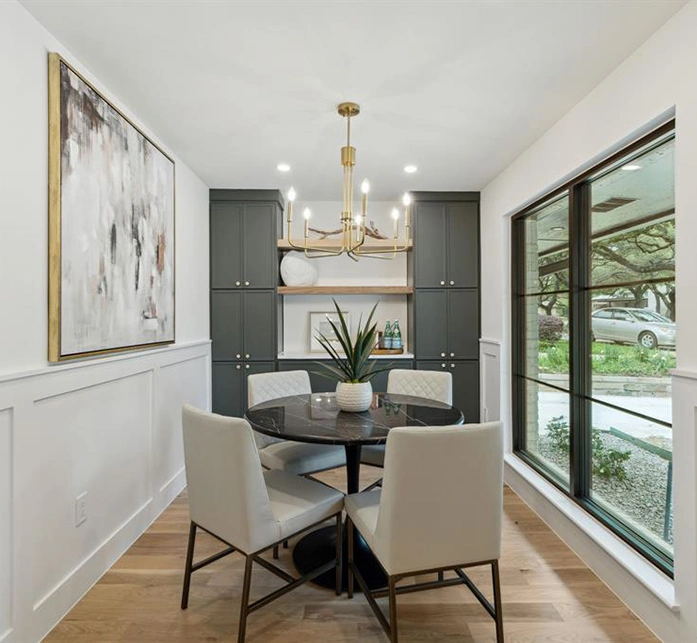 Round dining table with four leather chairs and large abstract artwork
