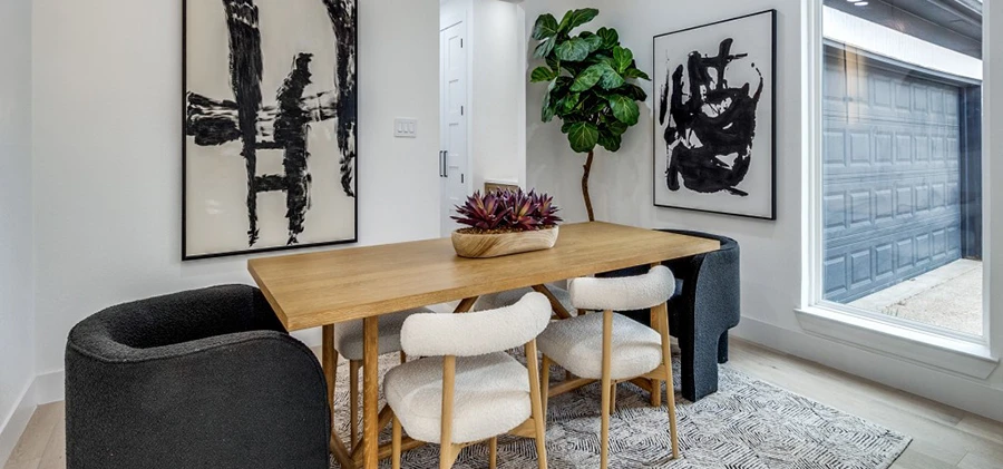 Large wood dining table, six chairs and two black and white abstract artwork pieces