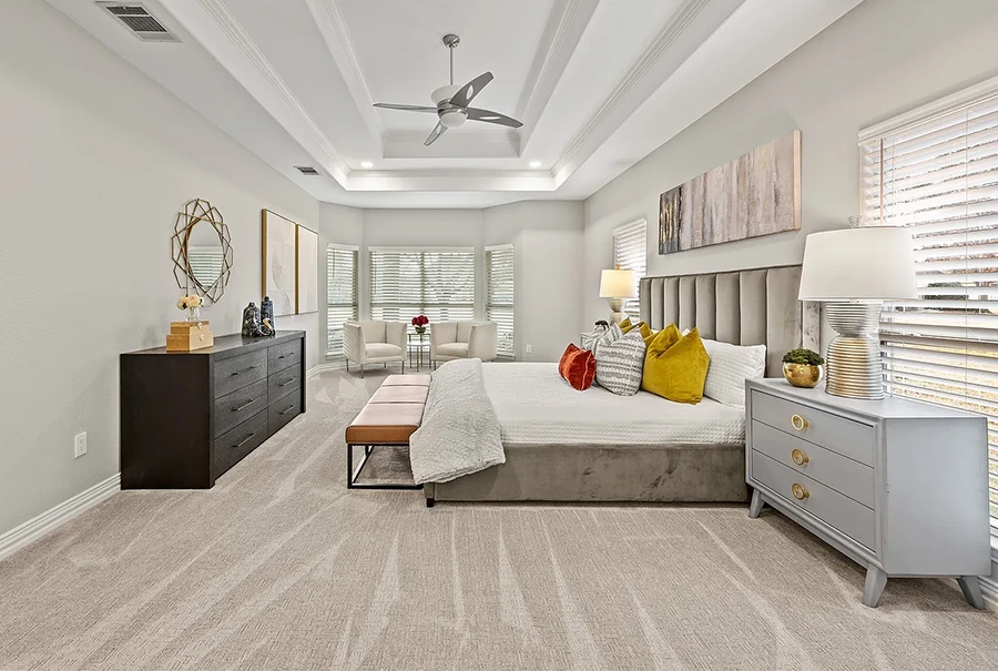 Luxury bedroom staged with upholstered bed and seating
