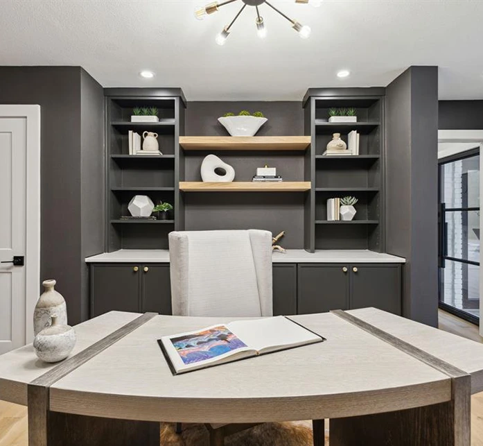 Home office staged with a modern light colored desk, grey desk chair and modern accessories
