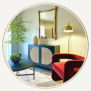itting area vignette featuring a teal and cane cabinet, a curved red velvet armchair, a gold floor lamp, and a wavy gold mirror