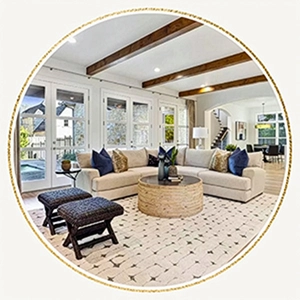 Staged living room with l-shaped sofa, blue and tan pillows and two black ottomans