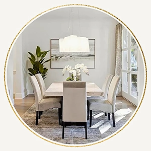 Staged dining room with large rectangular table, six white velvet chairs, abstract rug and large artwork