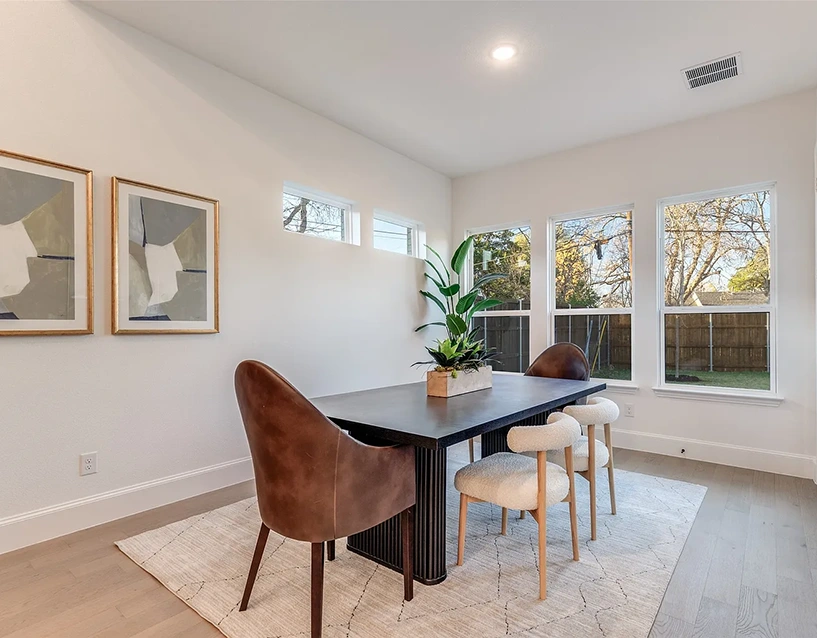 Luxury staged bedroom with upholstered bed, plush bedding and two modern white chairs