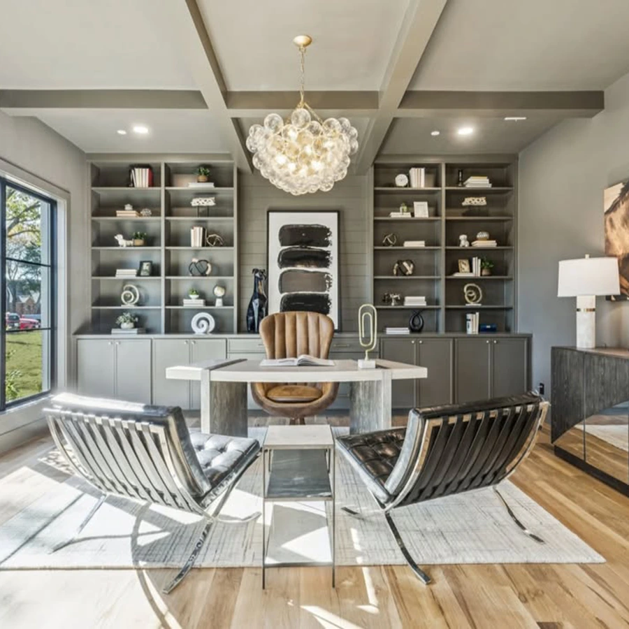 Elegant home office design with textured wallpaper, dark charcoal built-in cabinets, a light wood desk, and stylish cream-colored armchairs