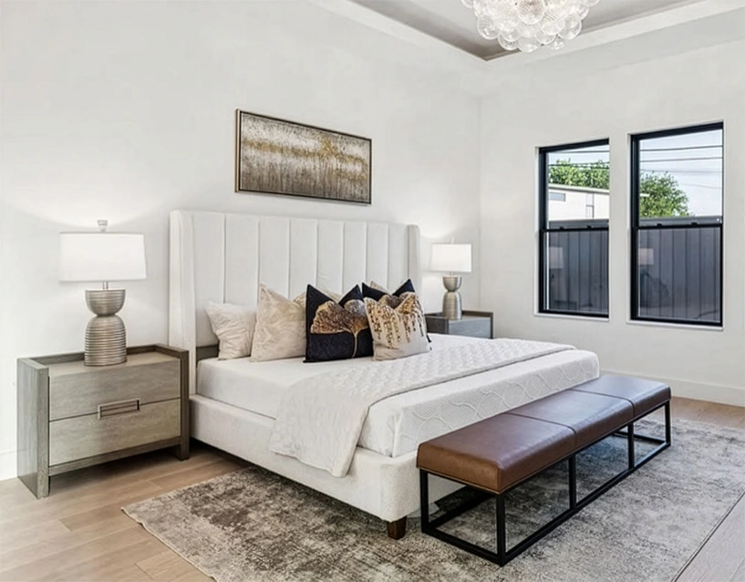 A secondary view of the light-filled Prestonwood living room, emphasizing the open floor plan and the connection between the indoor seating area and the outdoor patio seen through black-framed glass doors