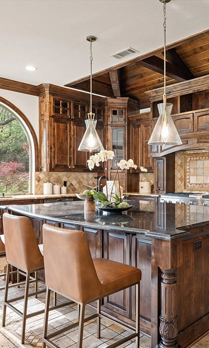 A kitchen area with rustic ark wood cabinetry, a large arched window, and cognac leather barstools