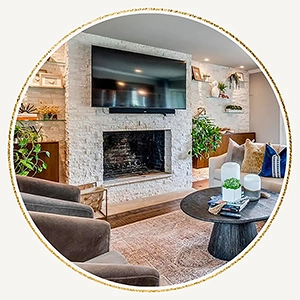 Fireplace surround staged with greenery, modern white vases and small shelving