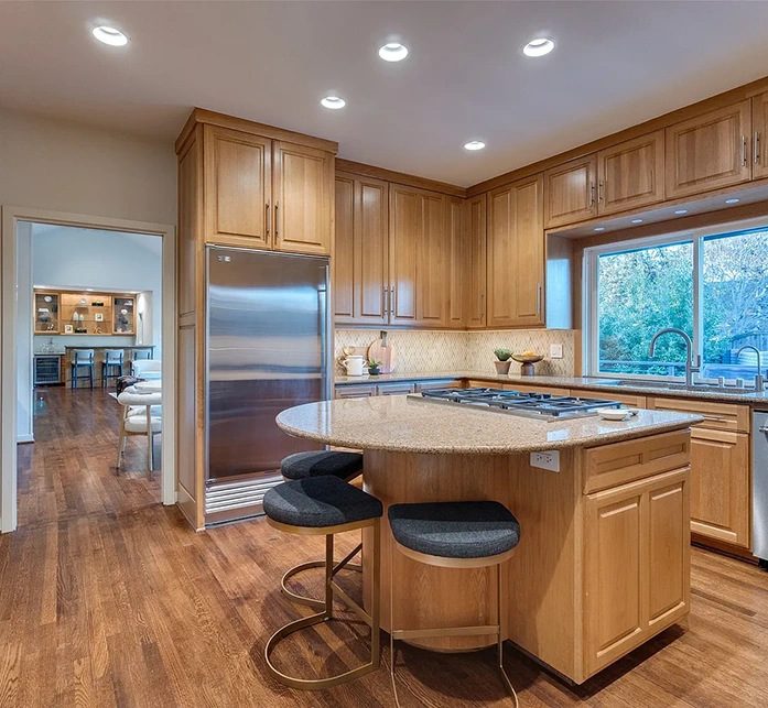 Kitchen staged with three black and gold barstools and kitchen accessories