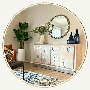 Close up of a console table with mirror designs, a large round mirror and blue and white vases