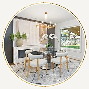 Staged dining room table with four white chairs, large rug and large abstract artwork over a fireplace
