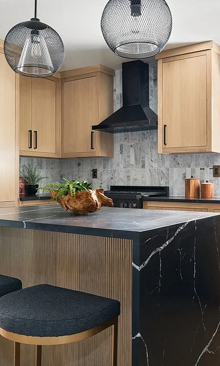 Modern kitchen staged with black and gold barstools, wooden and copper accents